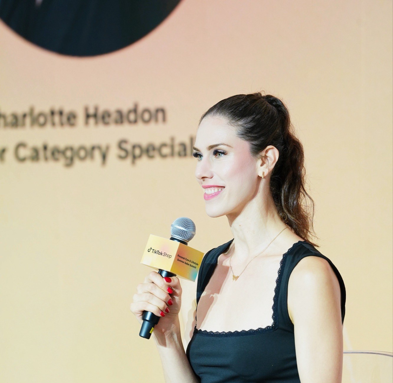 Cassandra Bankson speaking on stage with a microphone